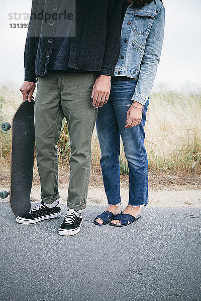 Niedriger Anteil von Freunden mit Skateboard auf der Straße stehend