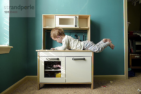 Junge liegt zu Hause auf Holzschrank