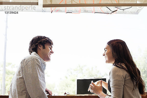 Freunde sitzen am Fenster im Kaffeehaus