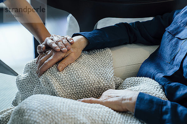 Ausgeschnittenes Bild einer Hauspflegerin  die eine ältere Frau tröstet