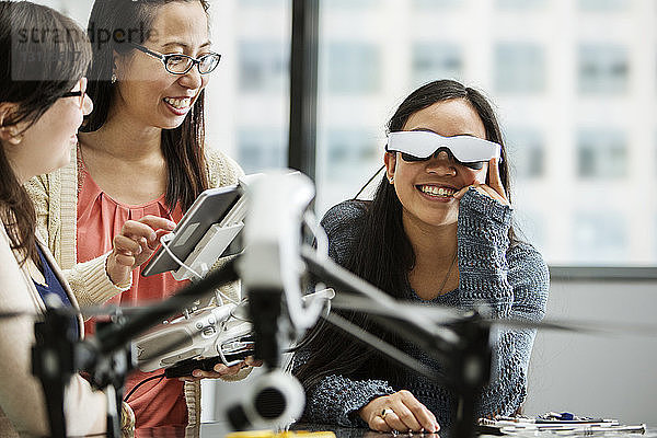 Studentin trägt eine Virtual-Reality-Brille  während der Lehrer einen Tablet-PC im Klassenzimmer benutzt