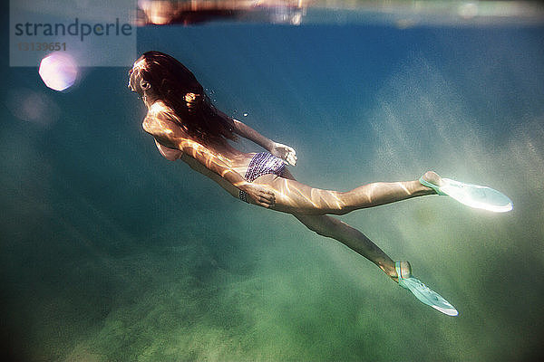 Seitenansicht einer im Meer schwimmenden Frau