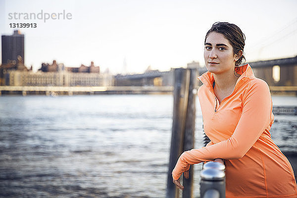 Porträt einer selbstbewussten Sportlerin  die am Beobachtungspunkt am East River steht