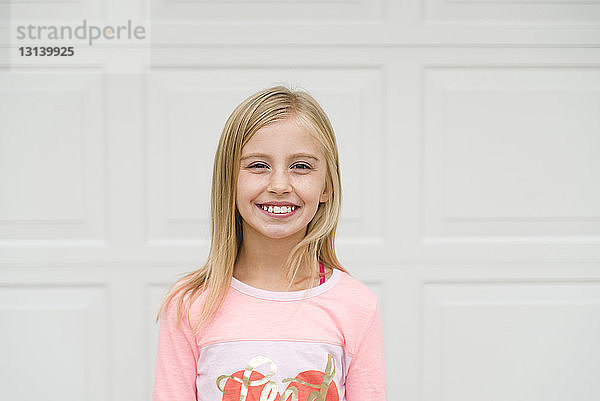 Porträt eines lächelnden Mädchens  das vor der Tür steht