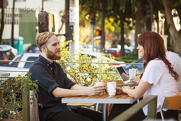 Junges Paar trinkt Kaffee im Straßencafé