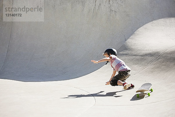 Junge fällt auf Skateboard-Rampe