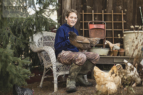 Porträt eines Jungen mit Hühnern auf einer Geflügelfarm