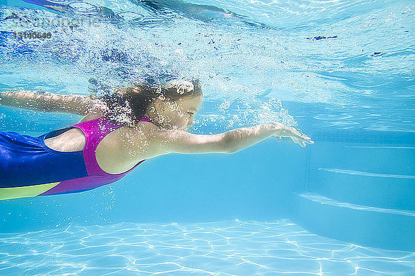 Seitenansicht eines unter Wasser schwimmenden Mädchens