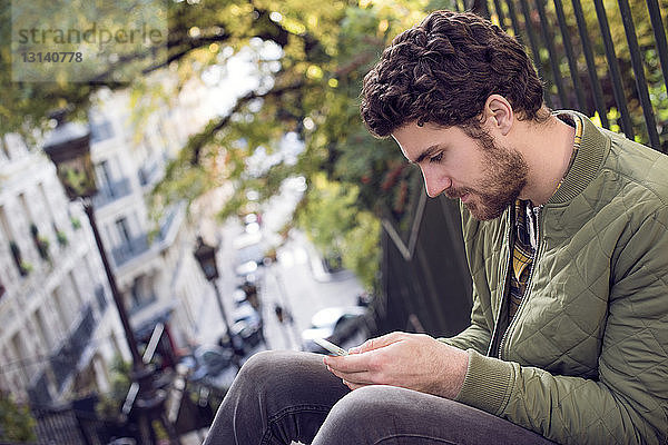 Mann mit Smartphone tritt in der Stadt