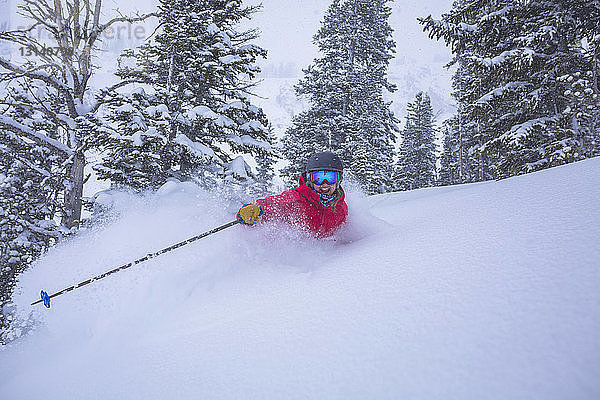 Fröhliche Frau beim Skifahren in schneebedeckter Landschaft