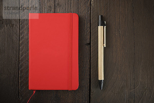 Draufsicht auf das Tagebuch mit Stift auf Holztisch
