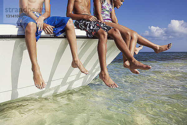 Niedriger Anteil von Kindern  die auf einem im Meer vertäuten Boot sitzen