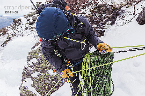 Wanderer mit Seilen beim Eisklettern in den Weissen Bergen im Winter