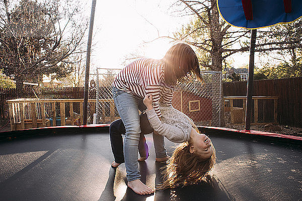 Schwestern spielen auf dem Spielplatz Trampolin