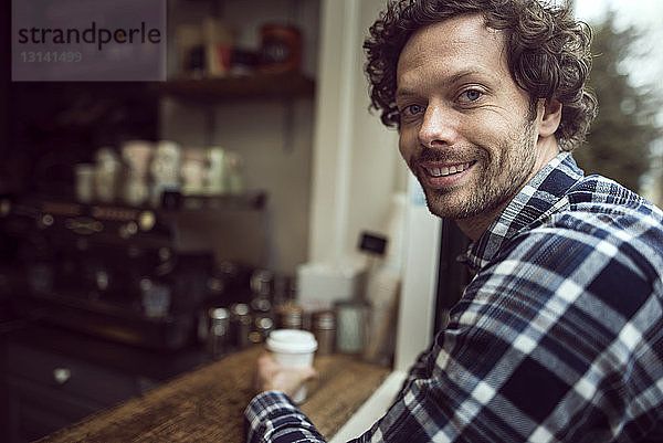 Seitenansicht Porträt eines glücklichen Mannes  der im Café sitzt