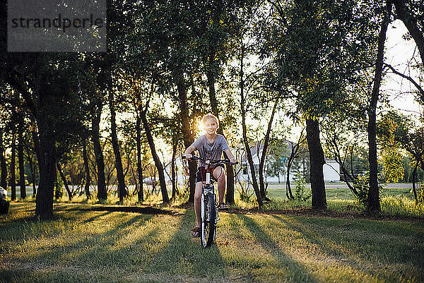 Porträt eines Fahrrad fahrenden Mädchens auf einem Grasfeld im Park