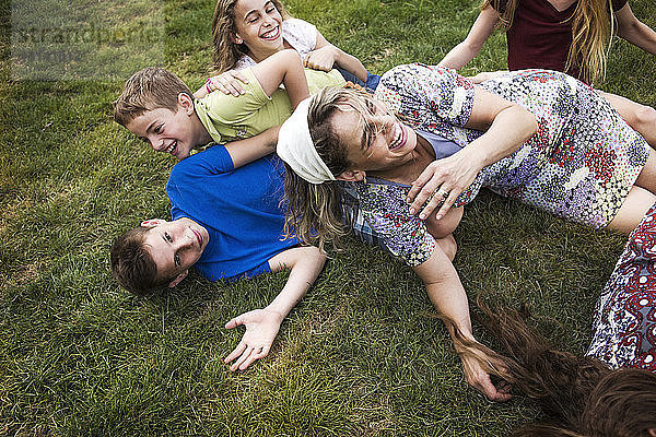 Mutter genießt mit Kindern auf Grasfeld im Park