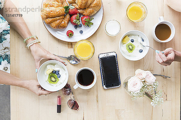 Draufsicht auf Freunde beim Frühstück am Tisch im Cafe