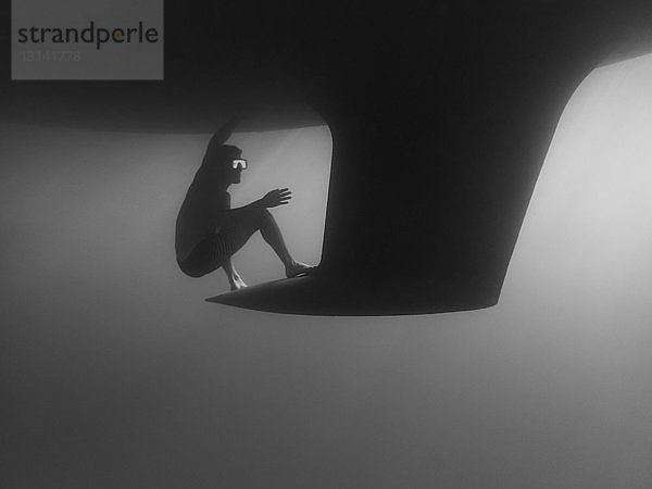 Seitenansicht eines Mannes  der unterseeisch am Kiel schwimmt