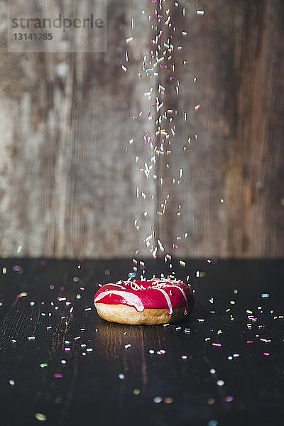 Streusel auf Donut am Holztisch