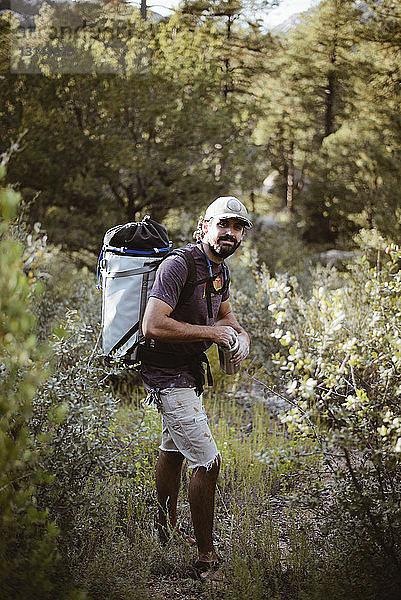 Porträt eines Wanderers  der einen Kreidepulverbehälter hält  während er auf einem Feld im Wald steht
