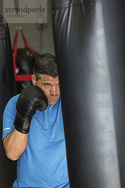 Männlicher Boxer übt im Fitnessstudio