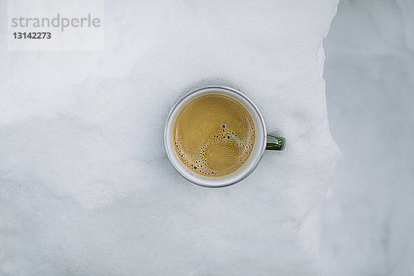 Draufsicht auf Kaffeetasse im Schnee