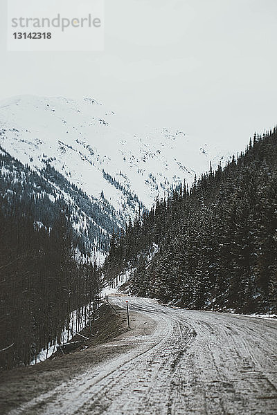 Straße inmitten der Berge im Winter