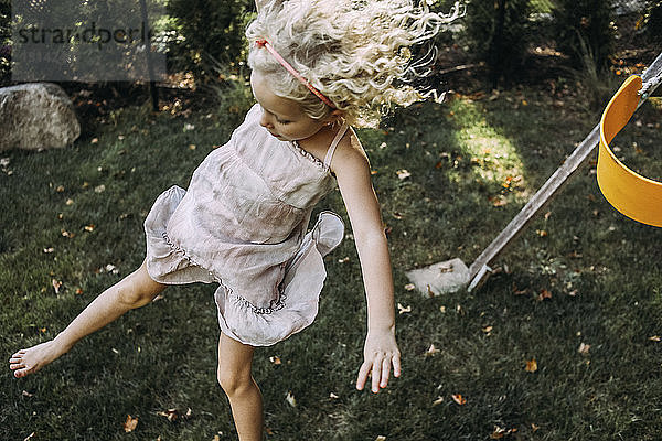 Hochwinkelaufnahme eines Mädchens  das auf dem Grasfeld eines Spielplatzes springt