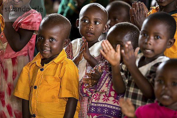 Kinder klatschen im Klassenzimmer in die Hände