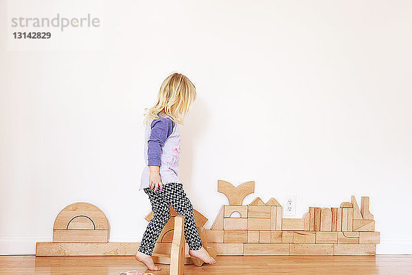 Seitenansicht eines Mädchens  das zu Hause mit Holzklötzen spielt