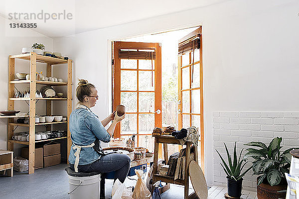 Frau hält Steingut bei Workshop