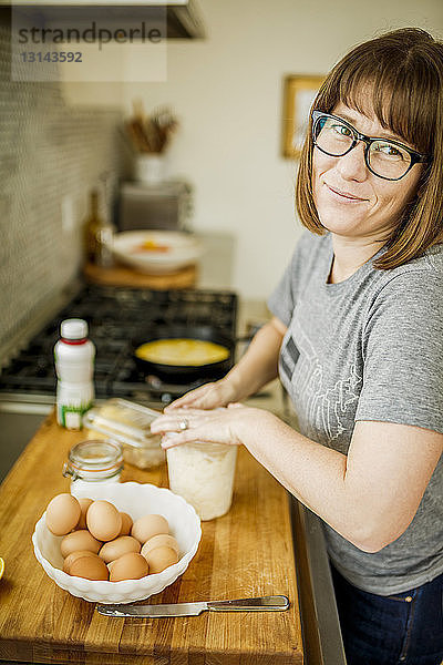 Porträt einer Frau  die zu Hause Essen zubereitet