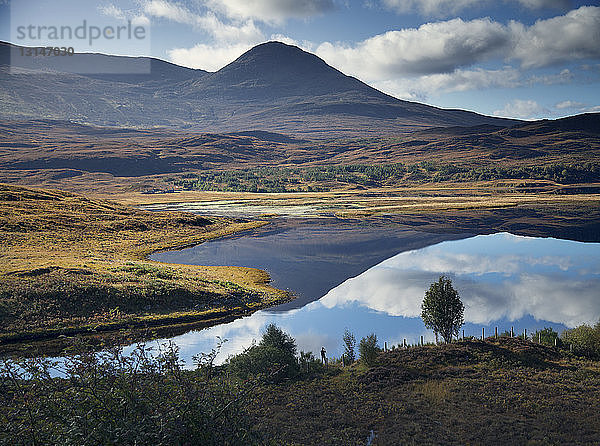 Mann fotografiert Spiegelung eines Berges in einem See  Highland  Schottland