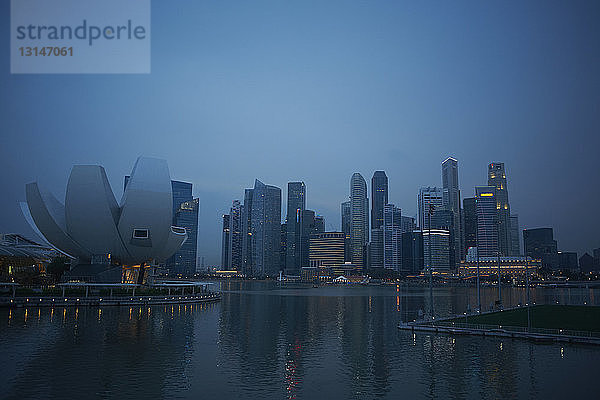 Blick auf die Wolkenkratzer der Stadt und die Uferpromenade in der Morgendämmerung  Singapur