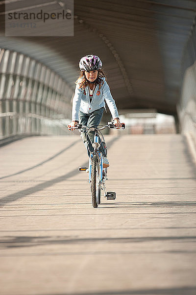 Mädchen fährt Fahrrad in einem Tunnel in der Stadt