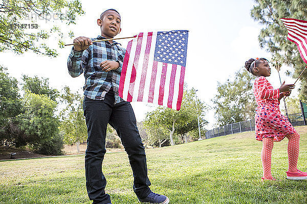 Kinder spielen mit amerikanischer Flagge im Park