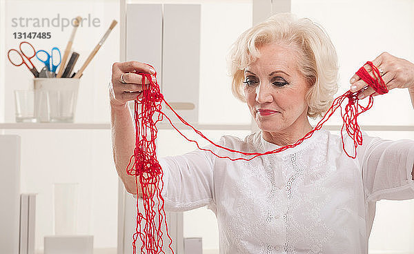 Ältere Frau mit verfilzter Wolle