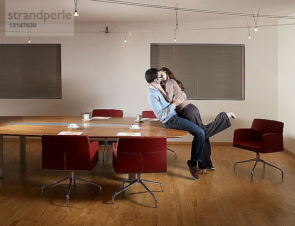 Mann und Frau küssen sich im Büro