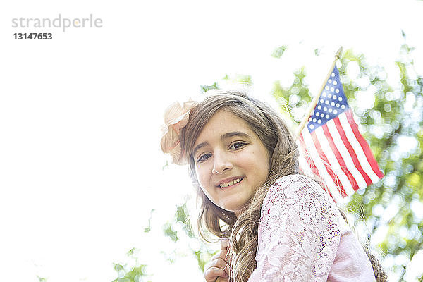 Porträt eines Mädchens mit amerikanischer Flagge im Park