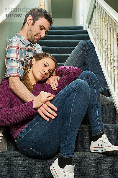 Junges Paar sitzt auf einer Treppe