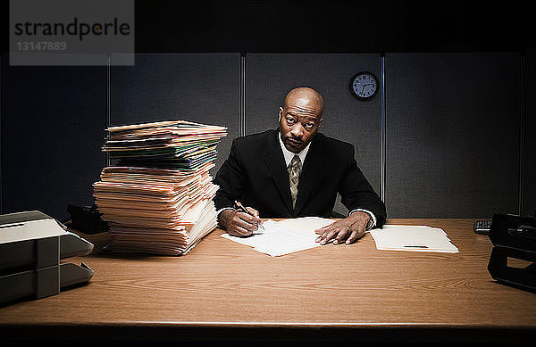 Geschäftsmann am Schreibtisch erledigt Papierkram