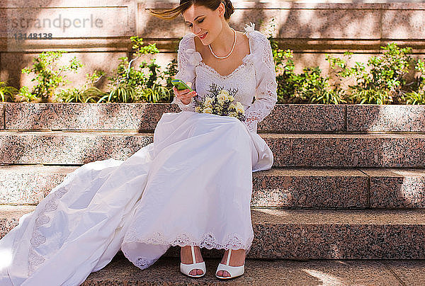 Braut überprüft Handy bei der Hochzeit