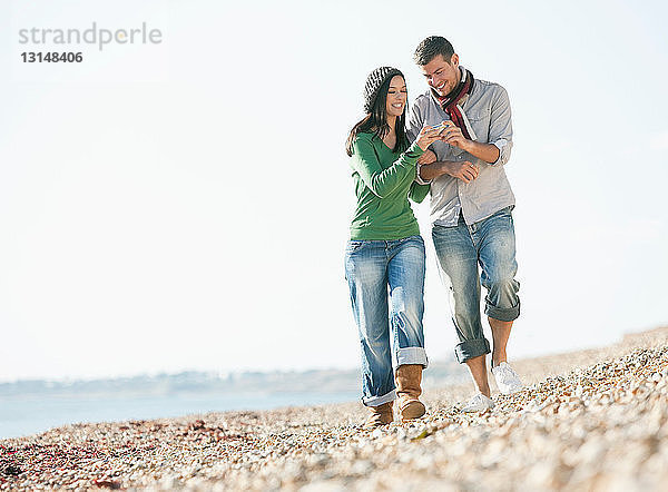 Junges Paar spaziert am Strand