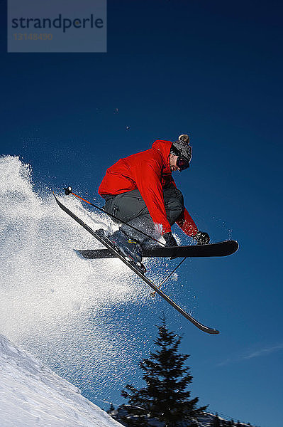 Ein Skifahrer springt in die Luft.