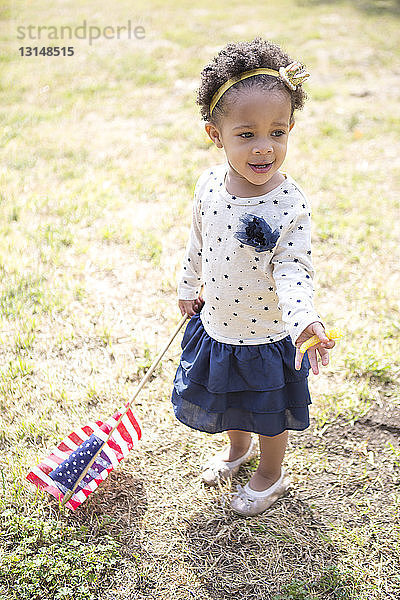 Kleinkind mit amerikanischer Flagge im Park