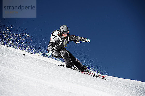 Frau beim Skifahren mit Geschwindigkeit den Berg hinunter