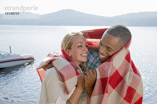 Junges Paar in Decke eingewickelt am See  Hadley  New York  USA