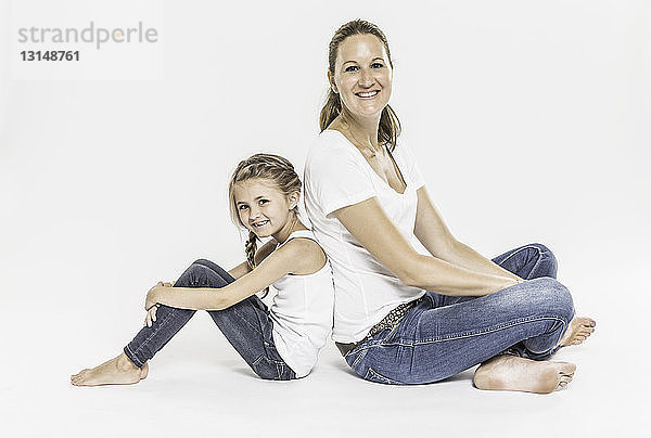 Porträt von Mutter und Tochter  Rücken an Rücken sitzend