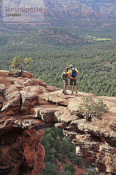 Wanderndes Paar mit Blick auf eine bogenförmige Felsformation  Sedona  Arizona  USA